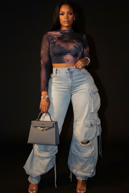 Person wearing light blue cargo pants and holding a gray handbag.